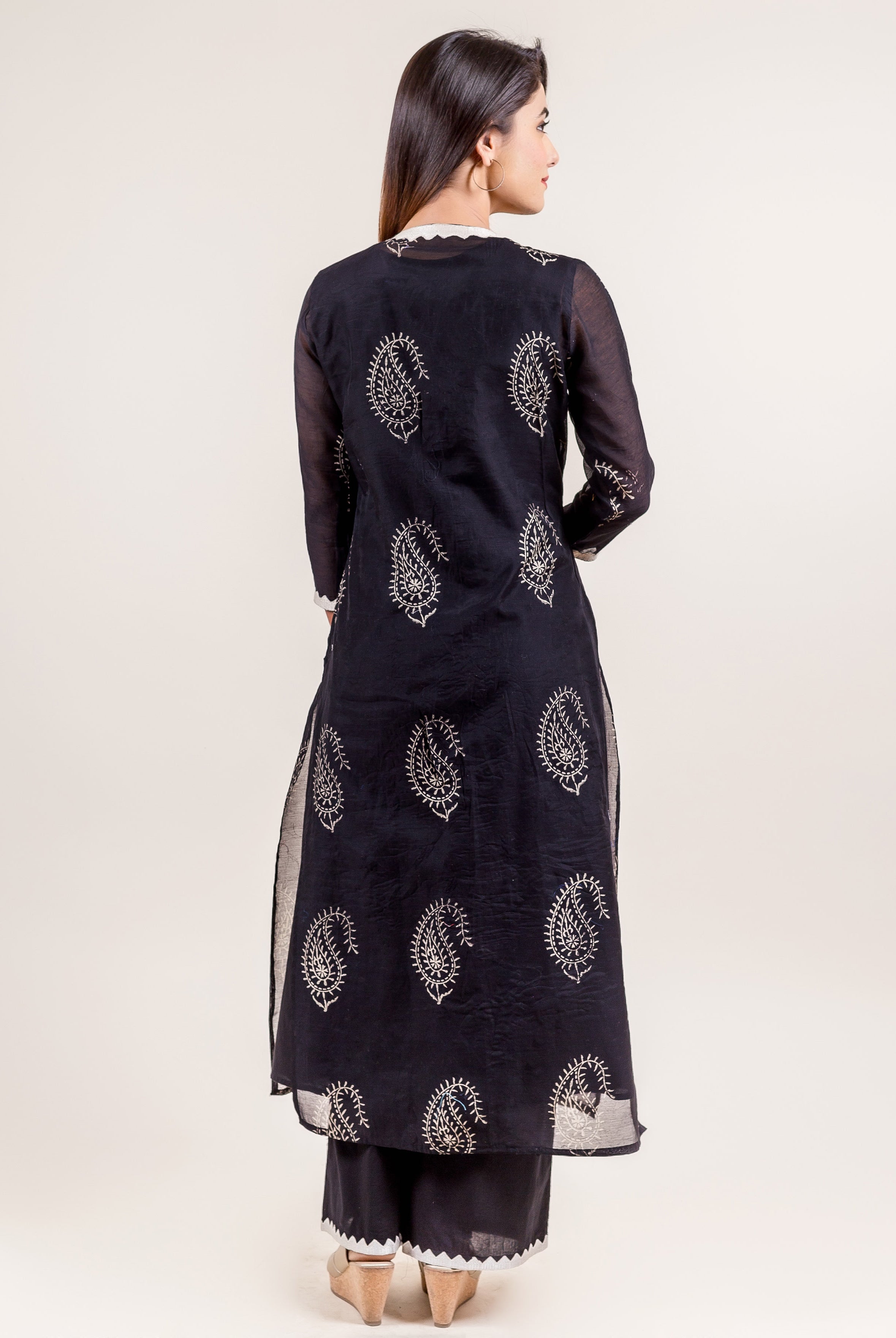Back view of model in black ethnic layered suit with white paisley block print.