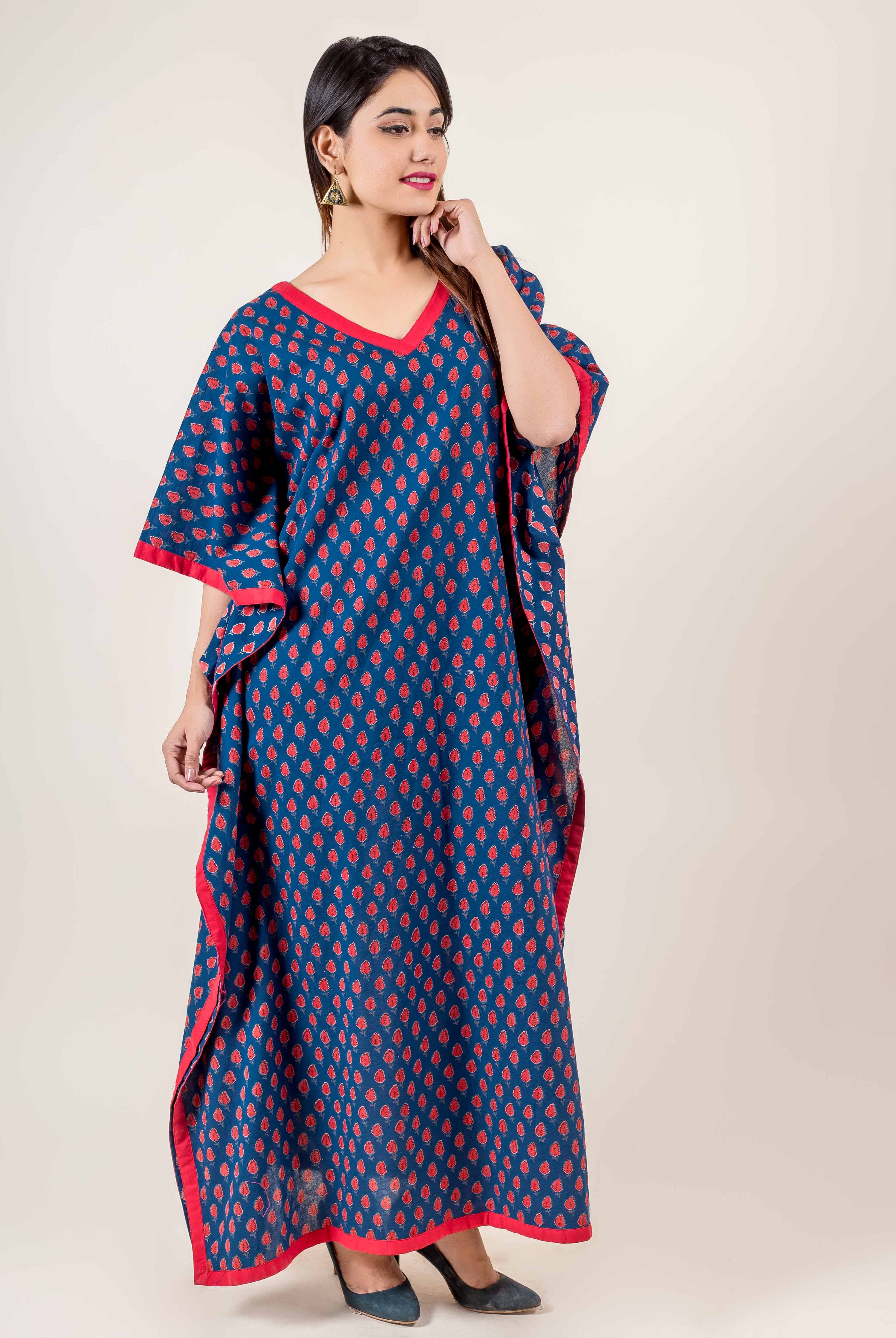Full look of model in blue hand block printed kaftan with red floral motifs and red trim.