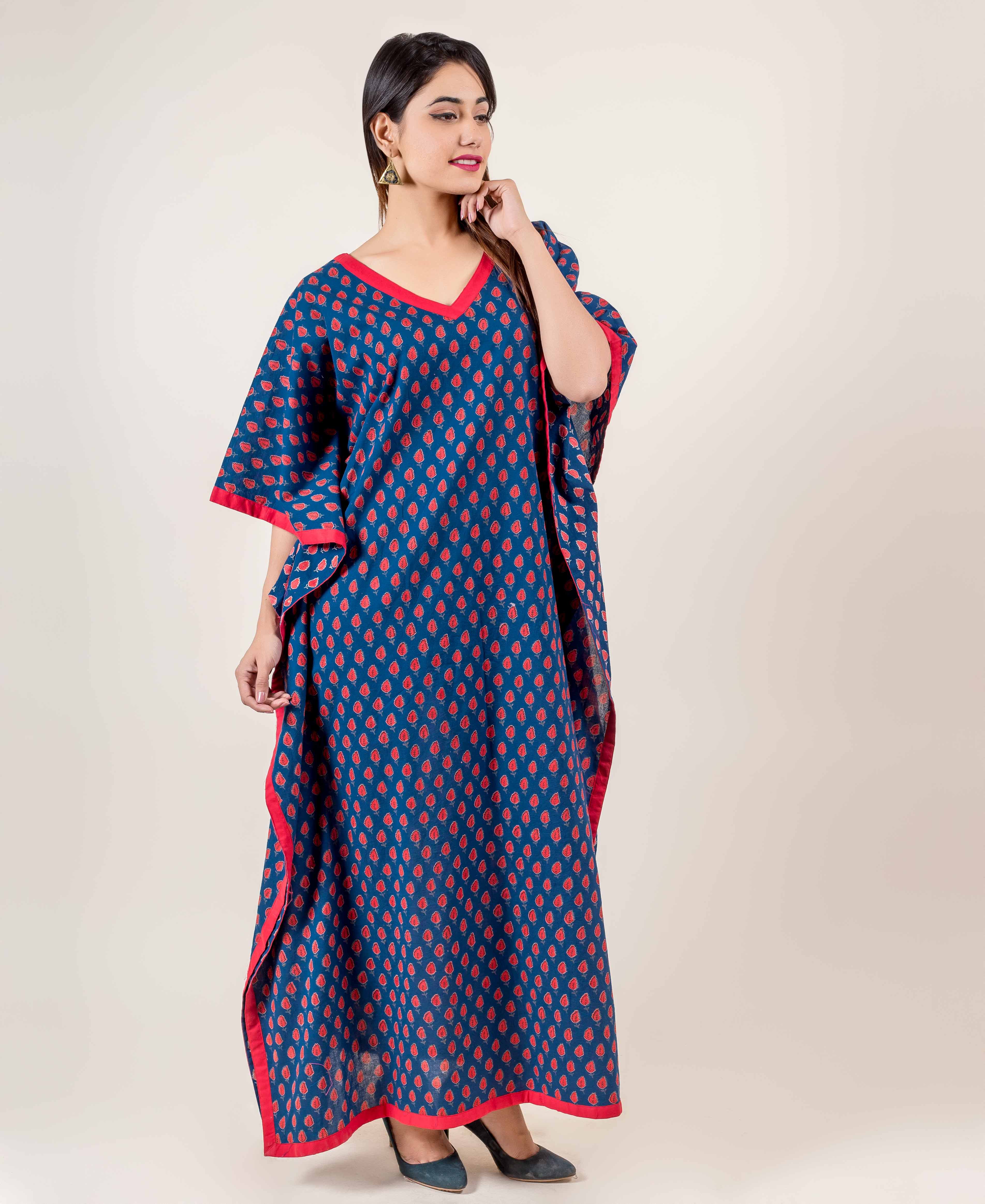 Full look of model in blue hand block printed kaftan with red floral motifs and red trim.