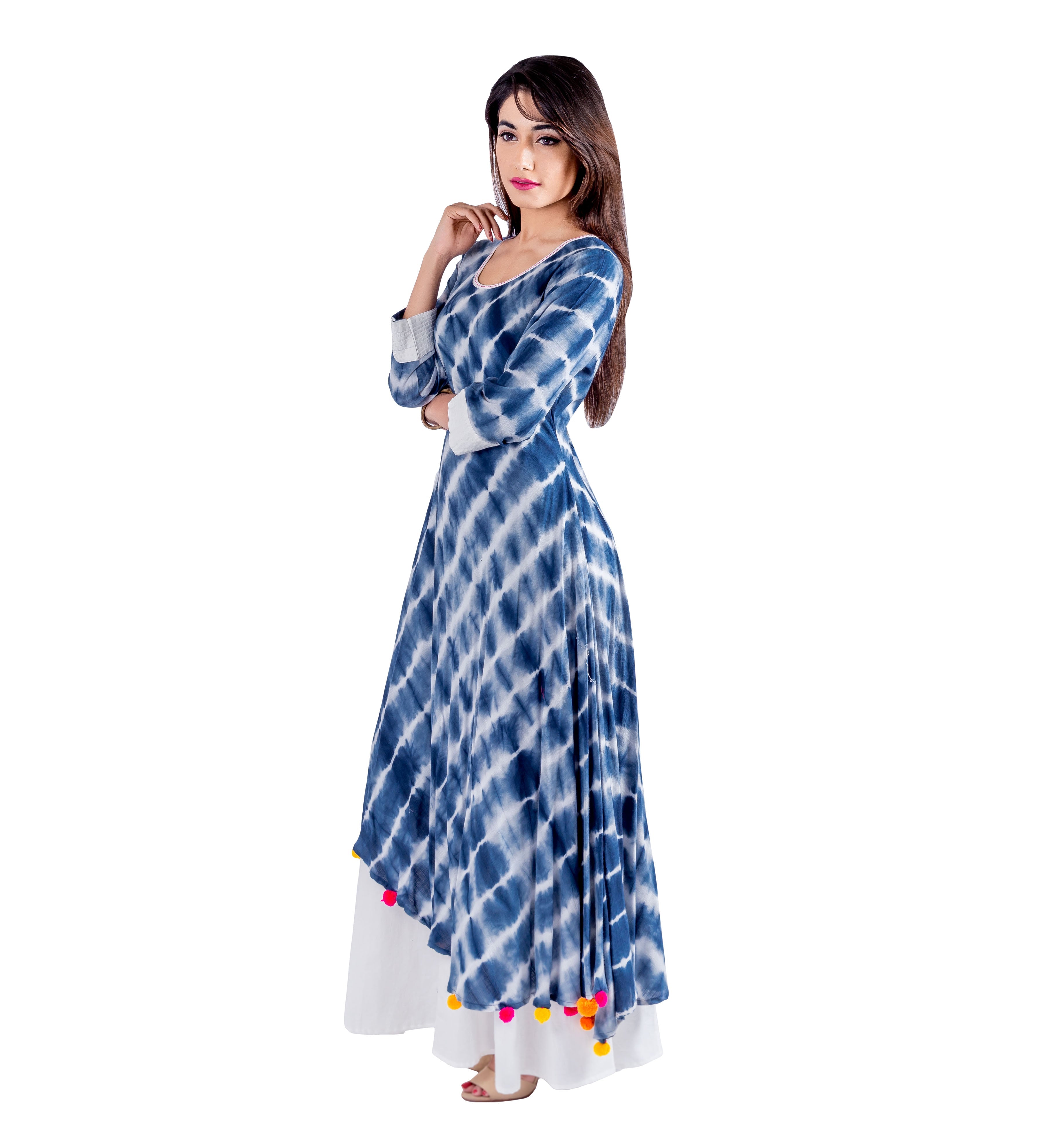 Model wears a blue and white tie-dye asymmetrical kurti dress with colorful pom-poms.