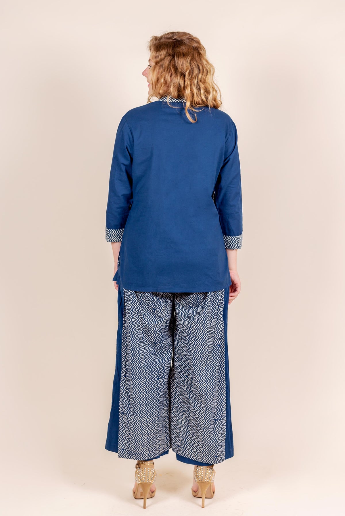 Back view of model wearing indigo kurti with zigzag cuffs and matching block print palazzo.