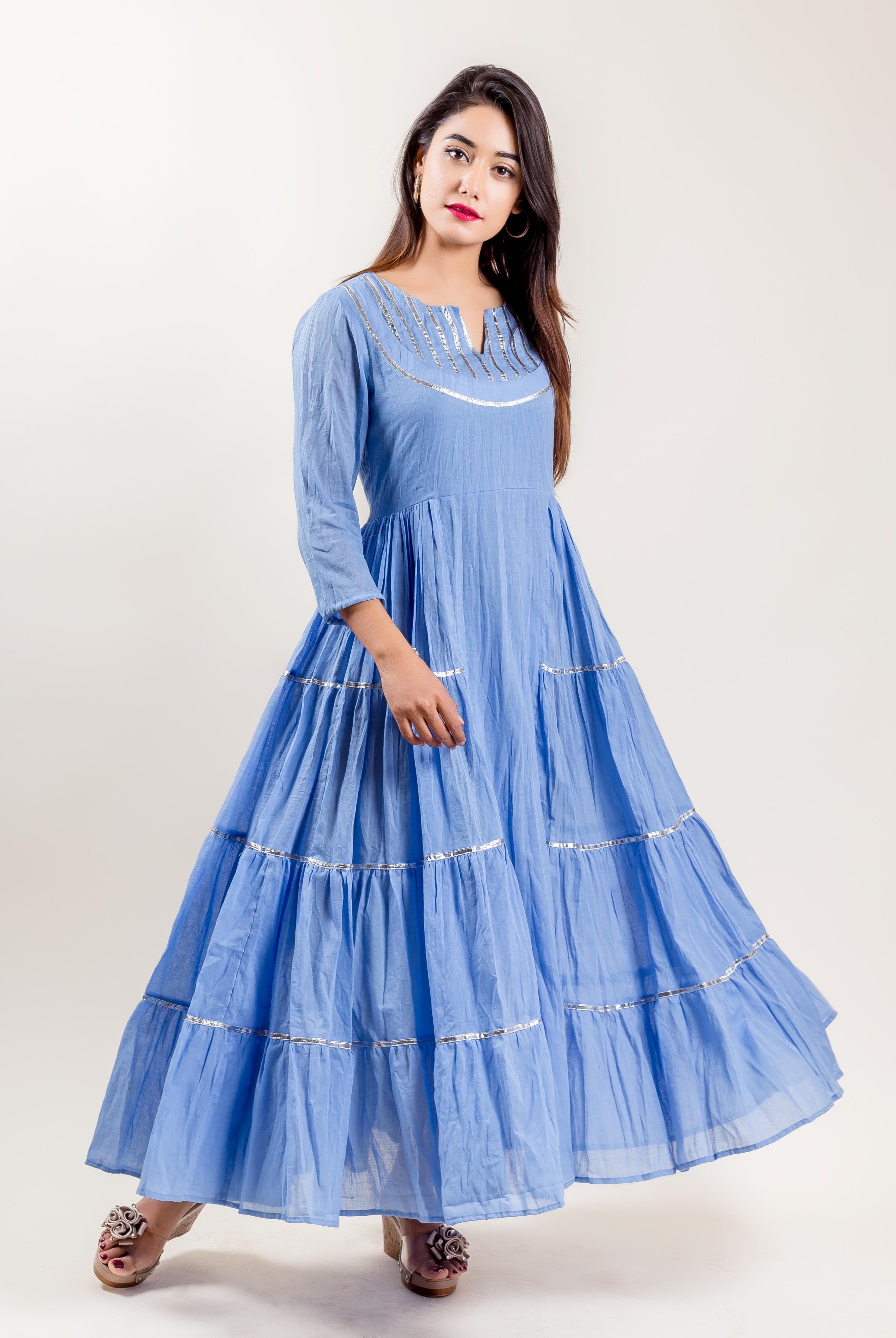 Full length front view of model in blue cotton tiered Indo-Western gown with silver trim.