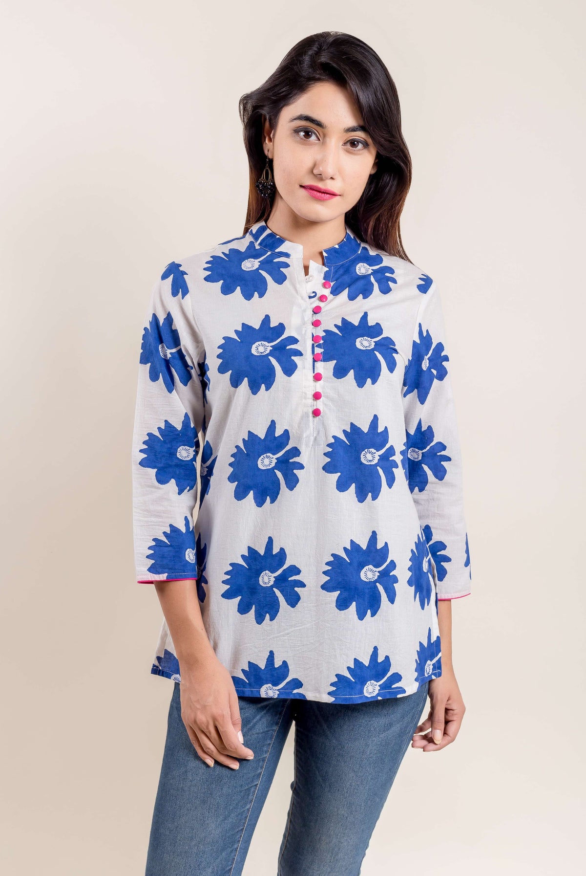 Model in blue and white floral hand block printed short kurti, mandarin collar, pink buttons.