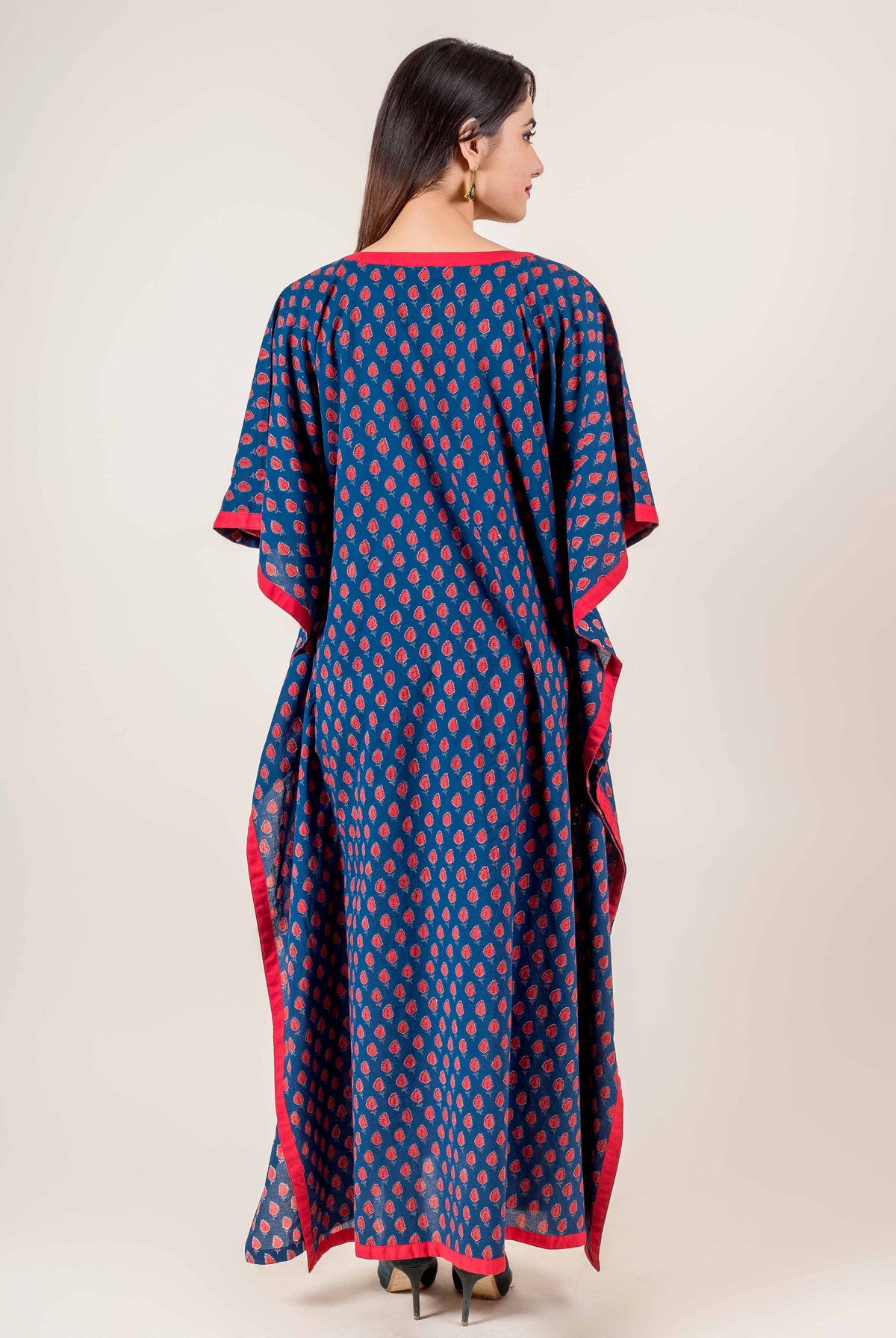 Back view of full-length blue hand block printed kaftan with red motifs and red trim.