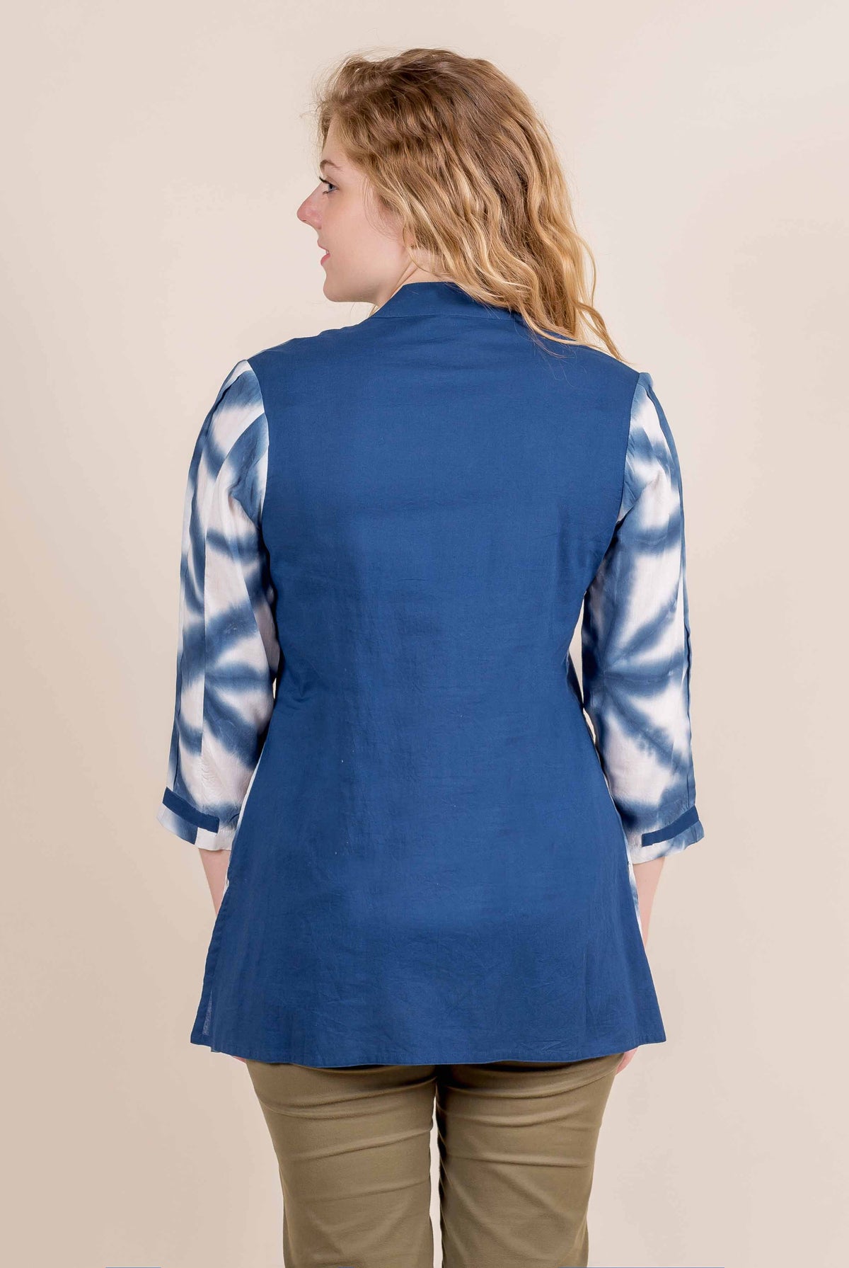 Back view of model wearing blue short kurta top with tie-dye sleeves.