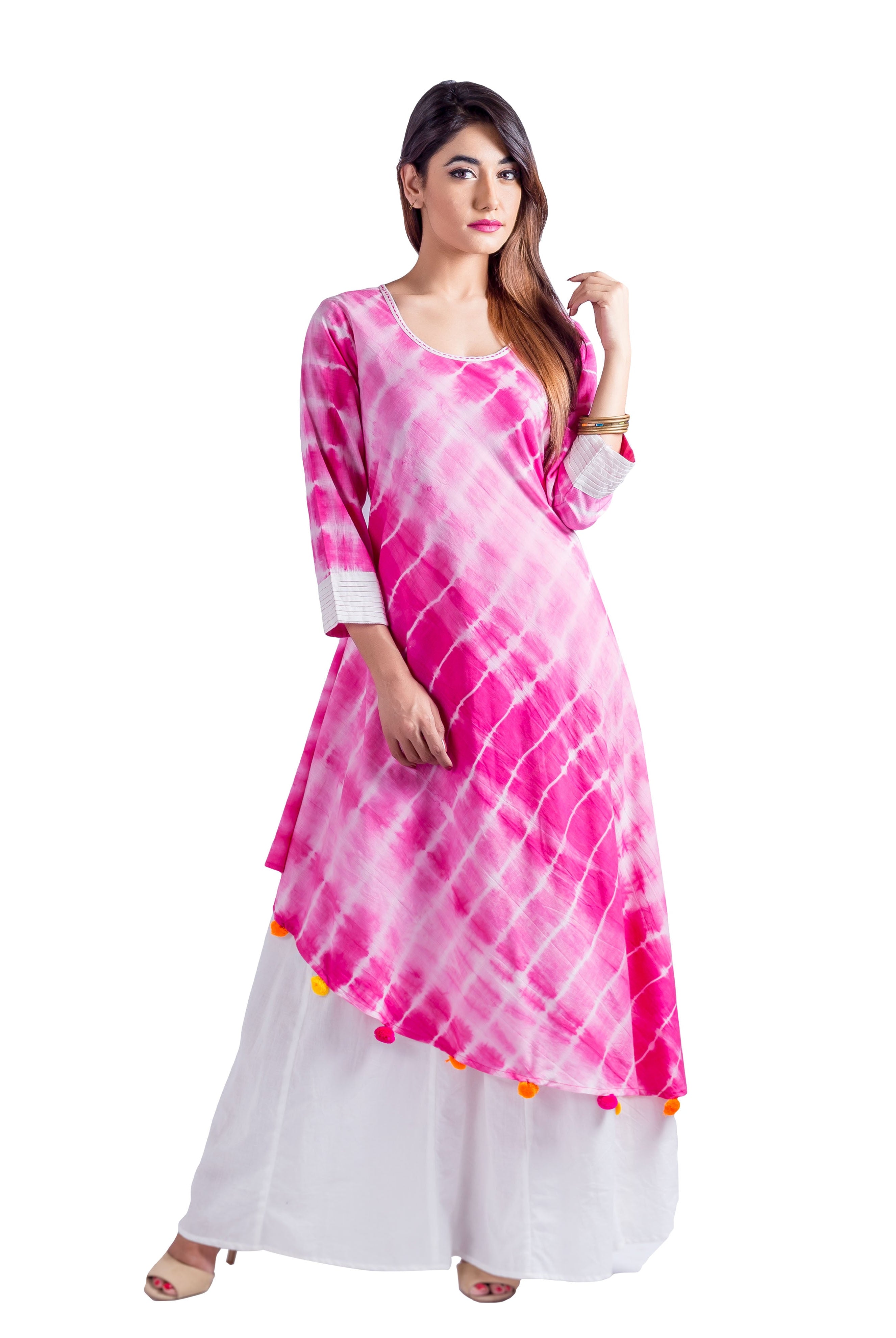 Full-length model in fuchsia and white tie-dye asymmetric kurta, white palazzos, with pom-poms.