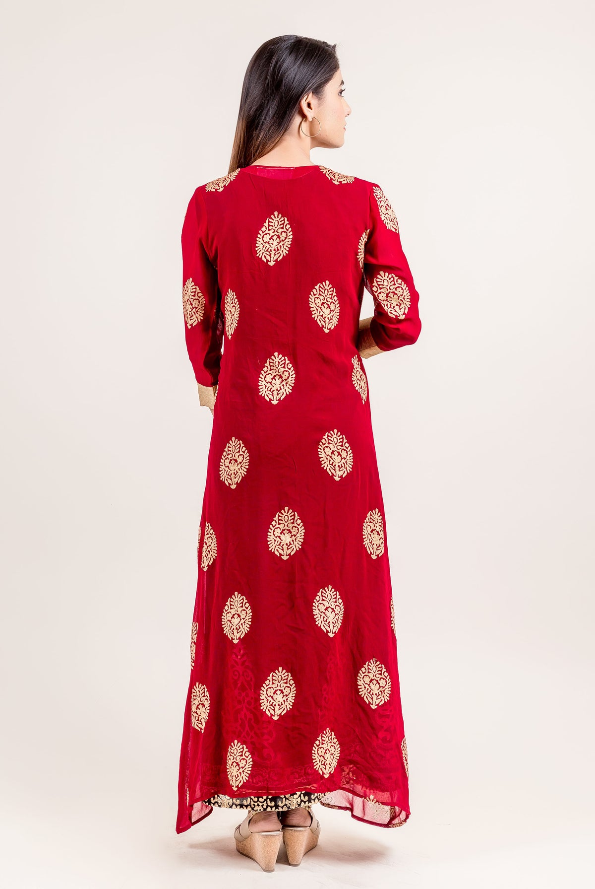 Back view of model in long red Indo-Western dress with gold block print.