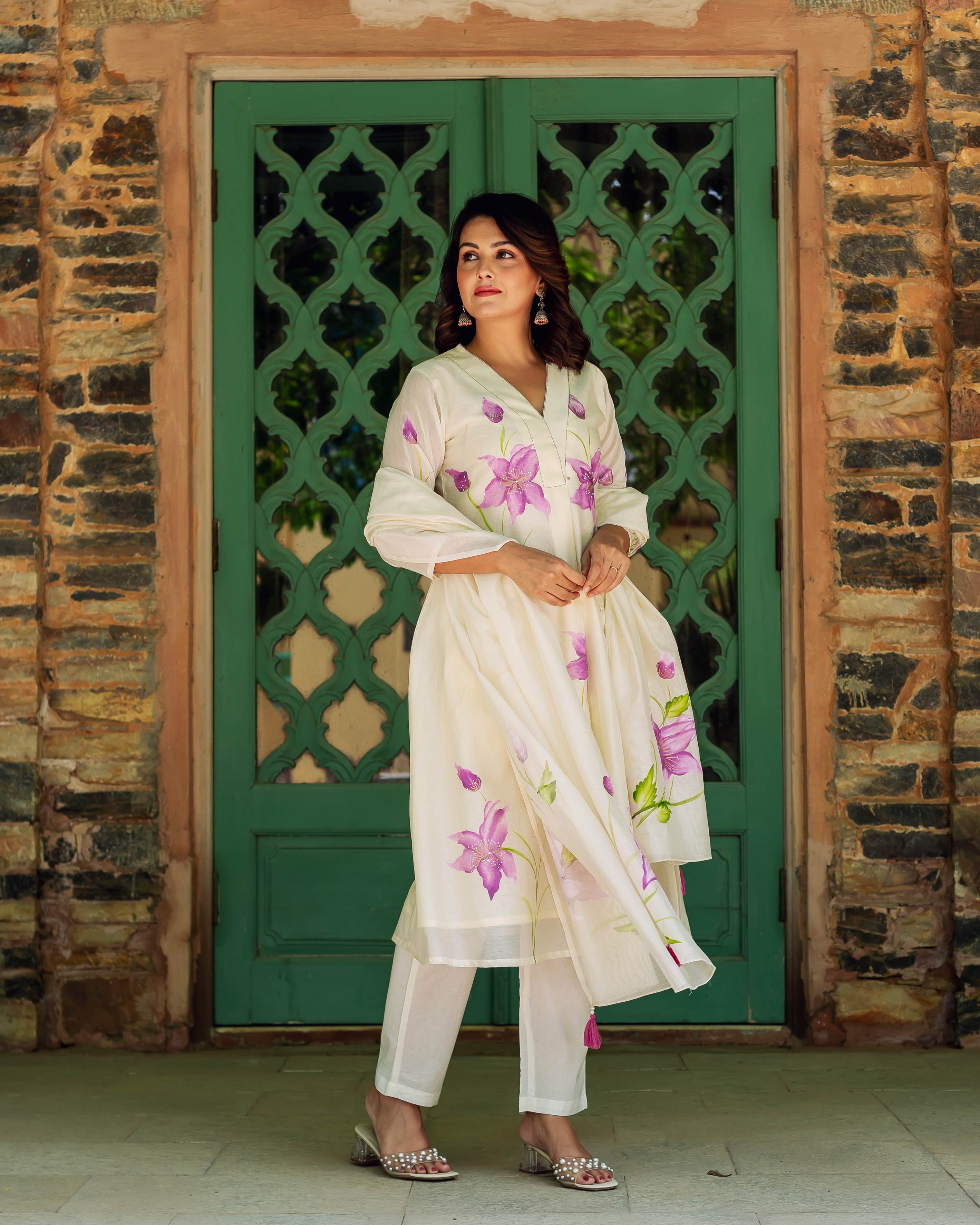 Model in an ivory hand-painted chanderi kurta with purple blossom motifs and pants.