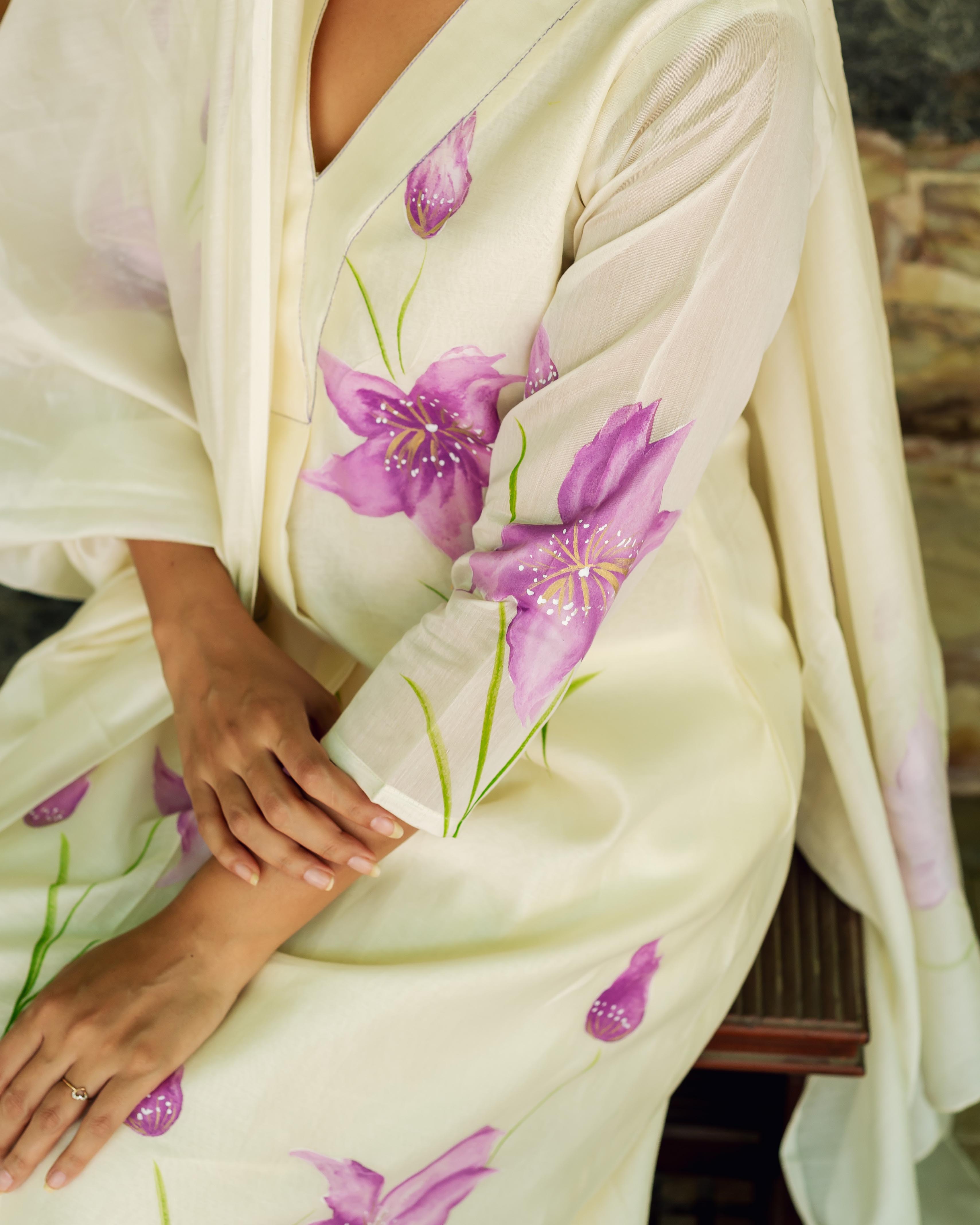 A model wears an ivory kurta with purple flowers and green stems.